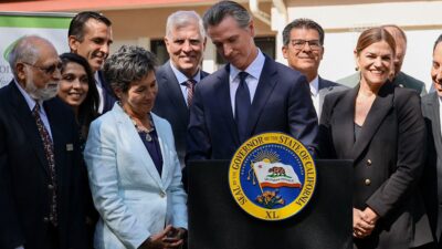 Governor Newsom signing CARE Act surrounded by smiling people
