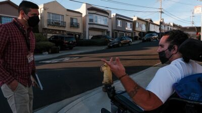 Case manager Jesse Aires, left, accompanies Ofisi Latu around the neighborhood of the Daly City care facility where he now lives.