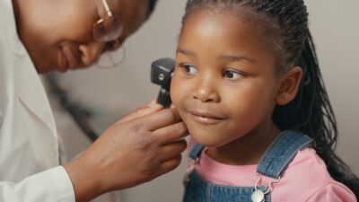 Little girl has her ears checked by physician