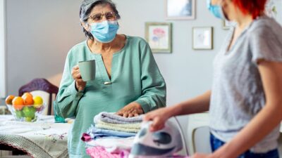 young woman helps older woman with laundry