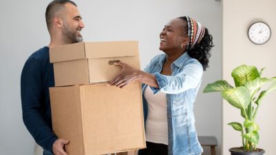man and woman moving boxes together