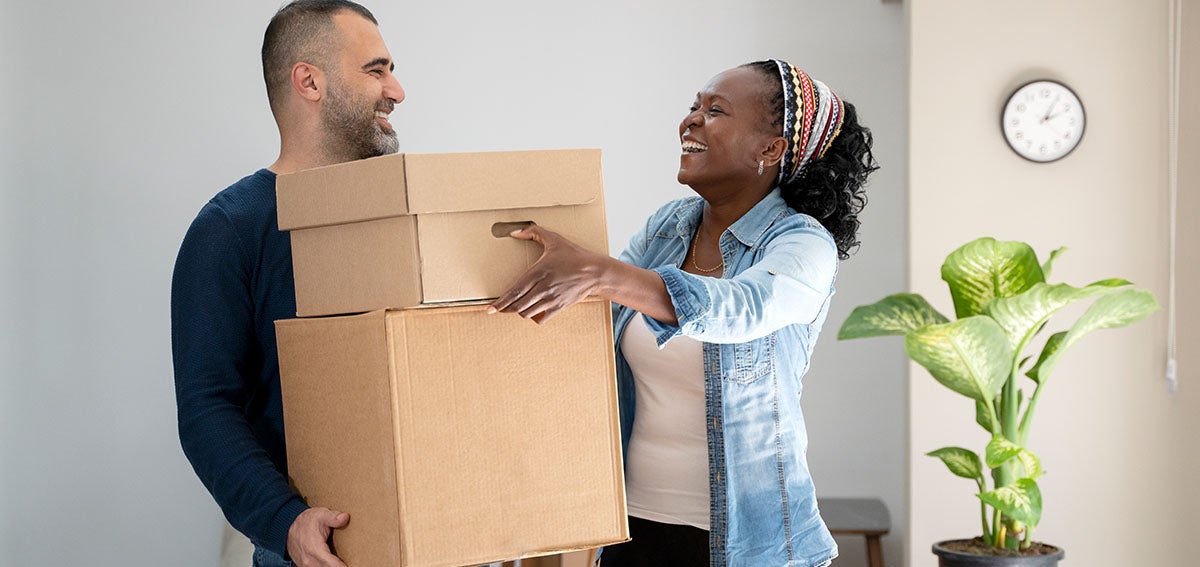 man and woman moving boxes together