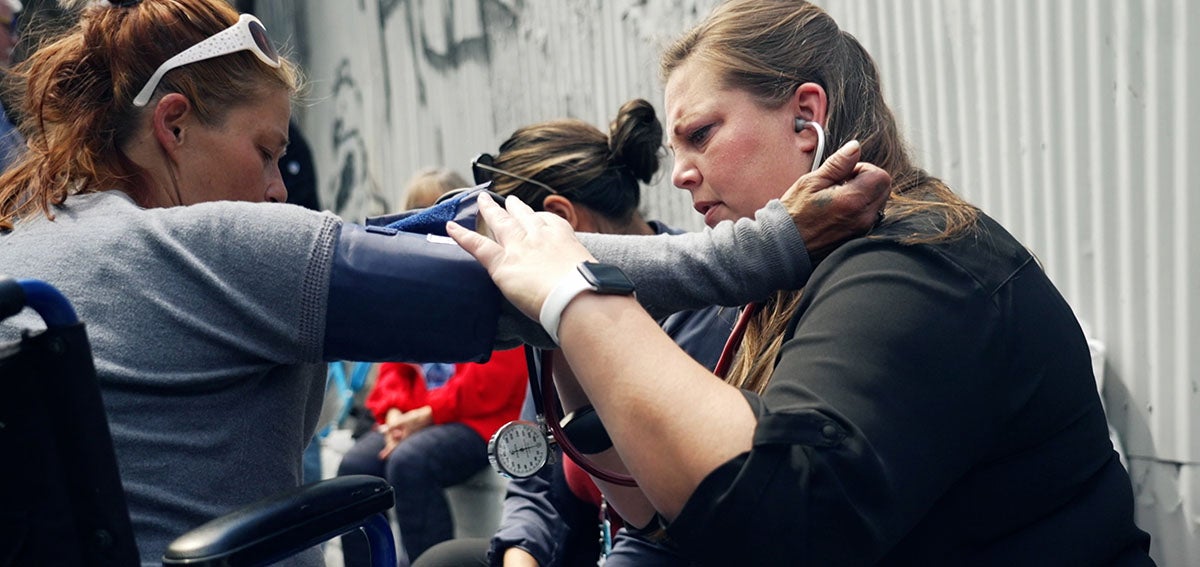 street medicine practitioner helps woman who is experiencing homelessness