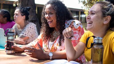 Community Health Workers sitting at table outdoors.