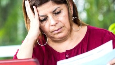 Woman reading bills, looking concerned