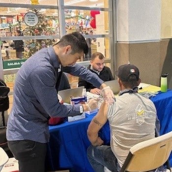 Photo of pharmacy staff giving a flu vaccination at a popup opportunity with SCAN Health Plan in Compton, CA in 2023.
