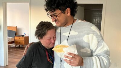 Carla Brown greets her occupational therapist, Julian Prado