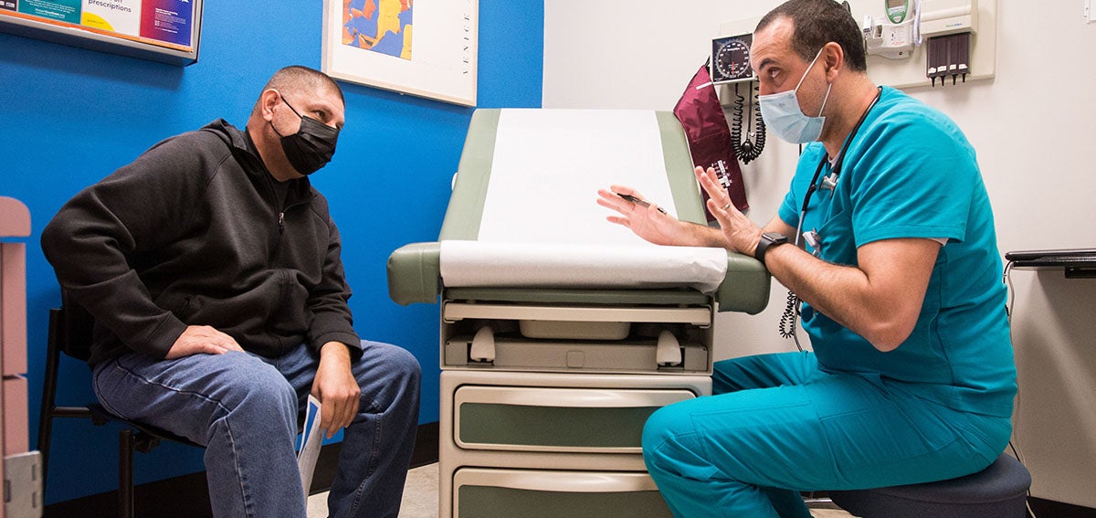 Patient and health care provide talk in clinic exam room.
