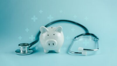 Piggy bank with stethoscope draped around it.