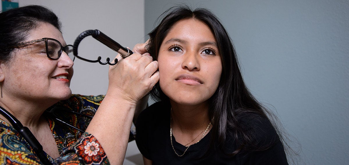 Doctor examines a young woman's ear