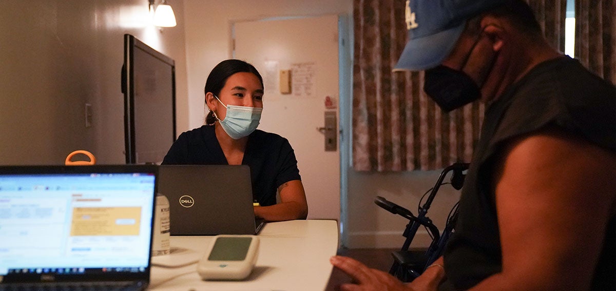 Physician assistant Samantha Kumpf talks with a transitional housing resident in Los Angeles during his doctor’s appointment in the same building as his apartment. October 2022.
