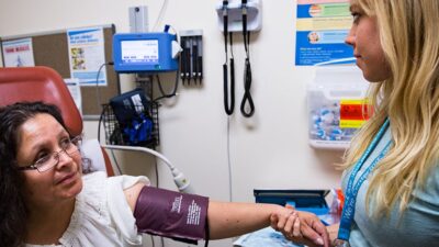 Physician Assistant taking patient's blood pressure.