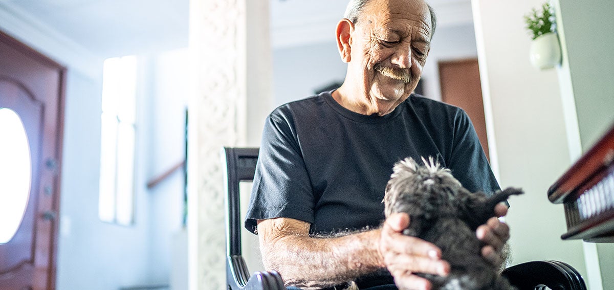 Elderly man petting his dog