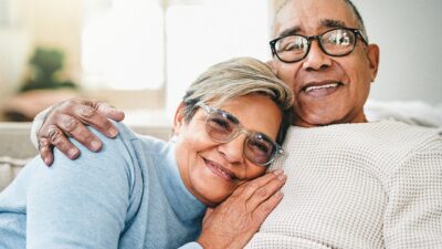 Happy senior couple sitting together on sofa.