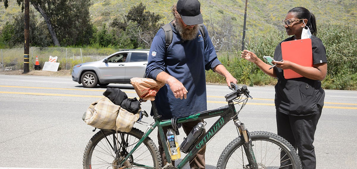 Medical practitioner reaches out to person experiencing homelesness.
