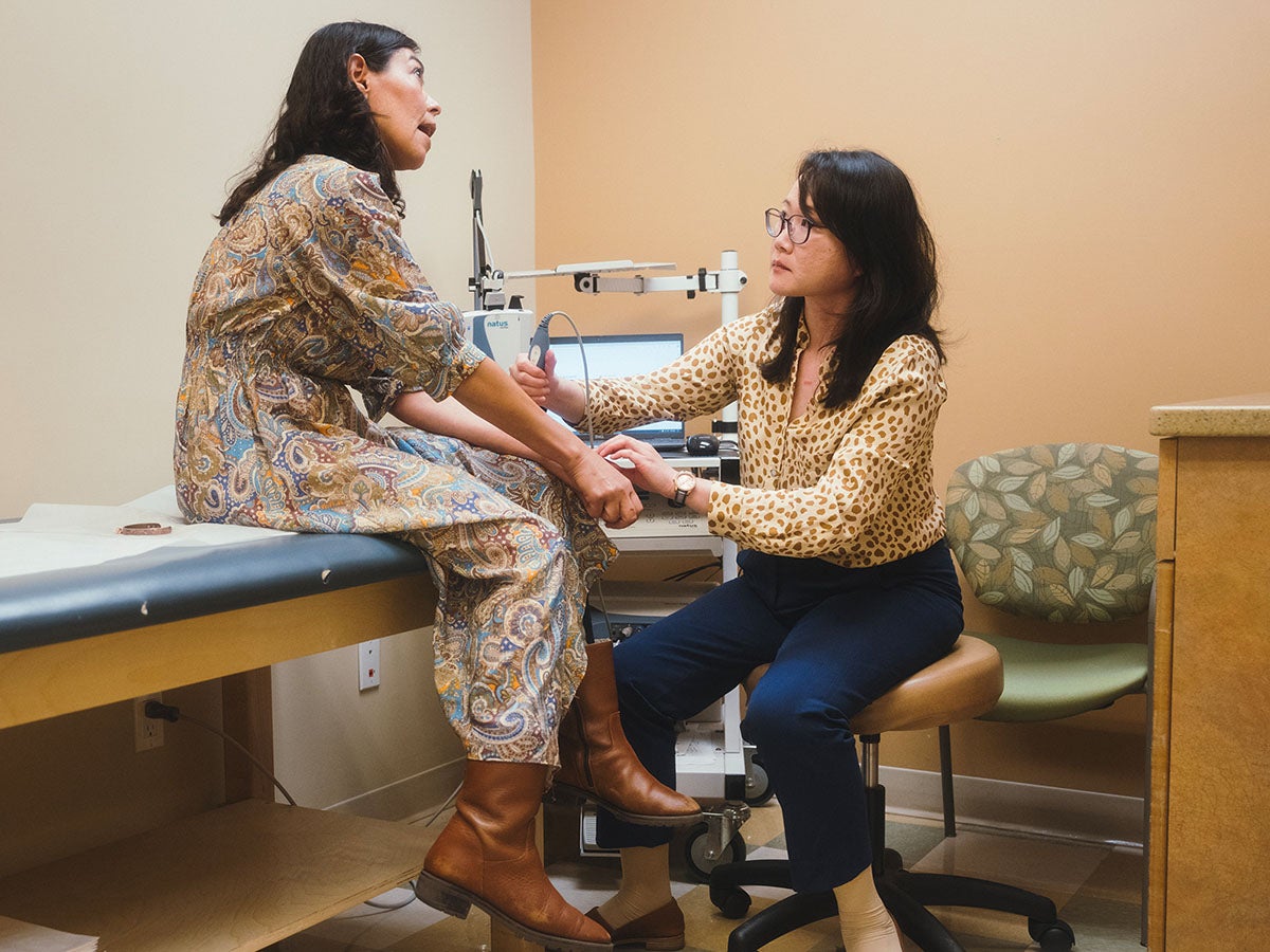 Doctor uses EMG to check nerve muscle stimulation of patient.