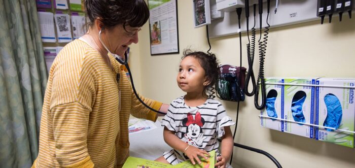Doctor listens to heartbeat of small child