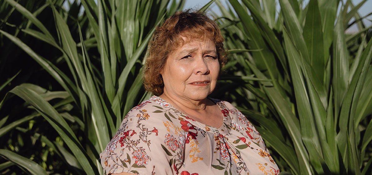 Medi-Cal Member Advisory Committee member stands in front of an agricultural field