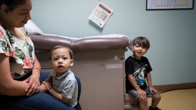 Mother and two children in clinic exam room