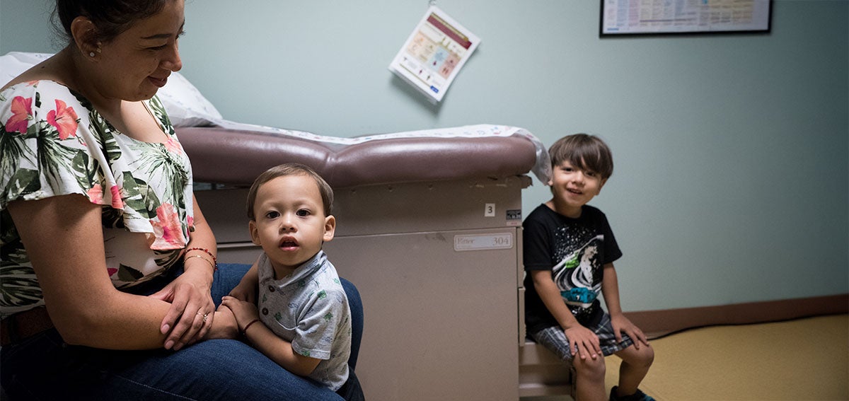 Mother and two children in clinic exam room