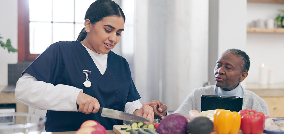 Home health aid helps client in the kitchen