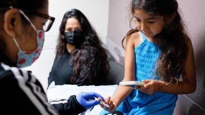 Mother an daughter at a medical clinic with doctor.