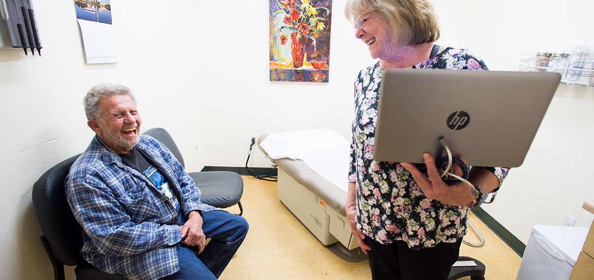 Patient and doctor laughing together diting a clinic visit