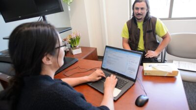Provide talks to patient while taking notes on a laptop.