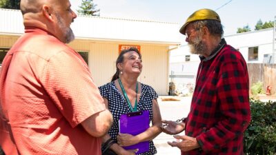 Community Health Workers talk to client outdoors