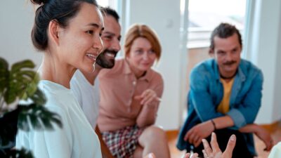 Group of men and women sitting together talking.