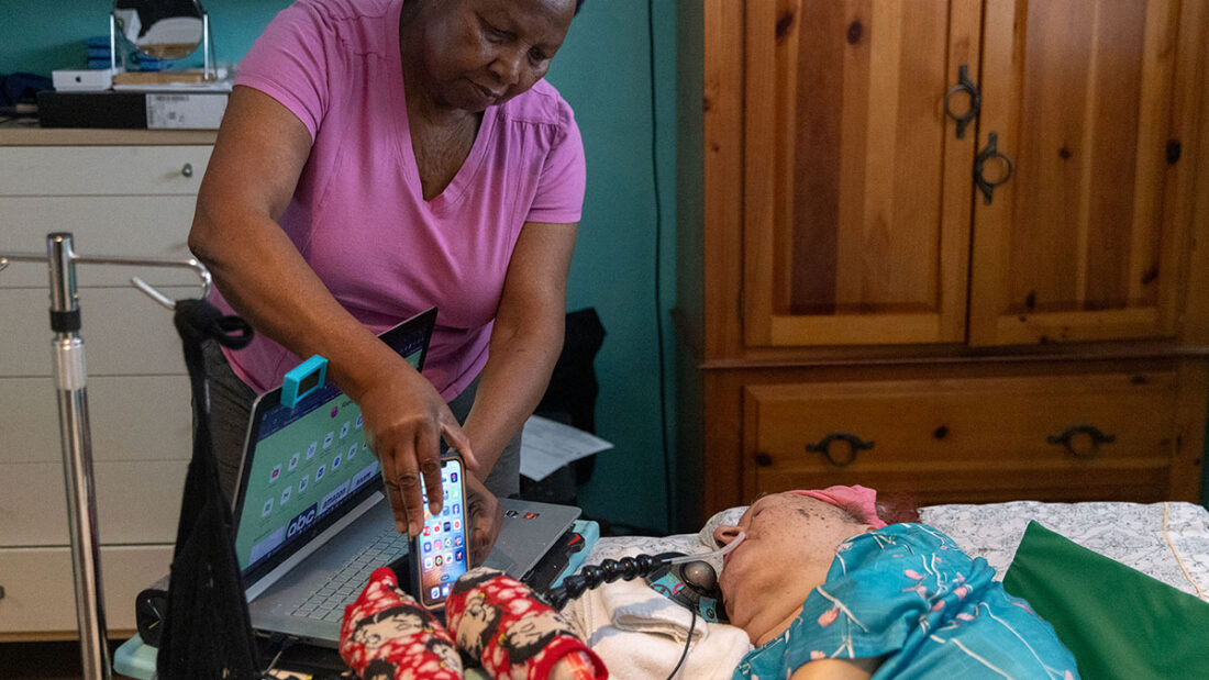 Caretaker Marie Locoh helps Cynde Soto at her home in Long Beach