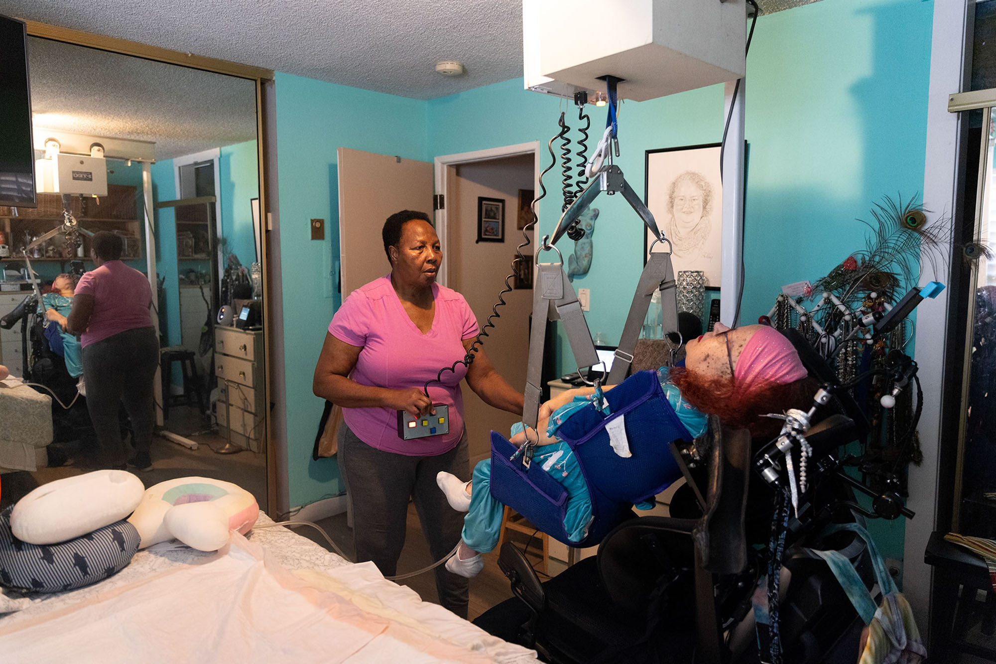 Longtime caretaker Marie Locoh helps Cynde Soto at her home in Long Beach