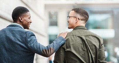 One black man places a reassuring hand on the shoulder of another black man.
