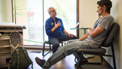 Doctor and patient talk in a clinical exam room.