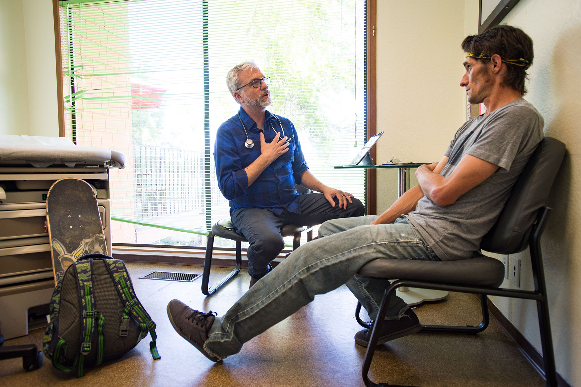 Doctor and patient talk in a clinical exam room.