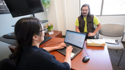 Doctor enters information on computer while talking to patient.