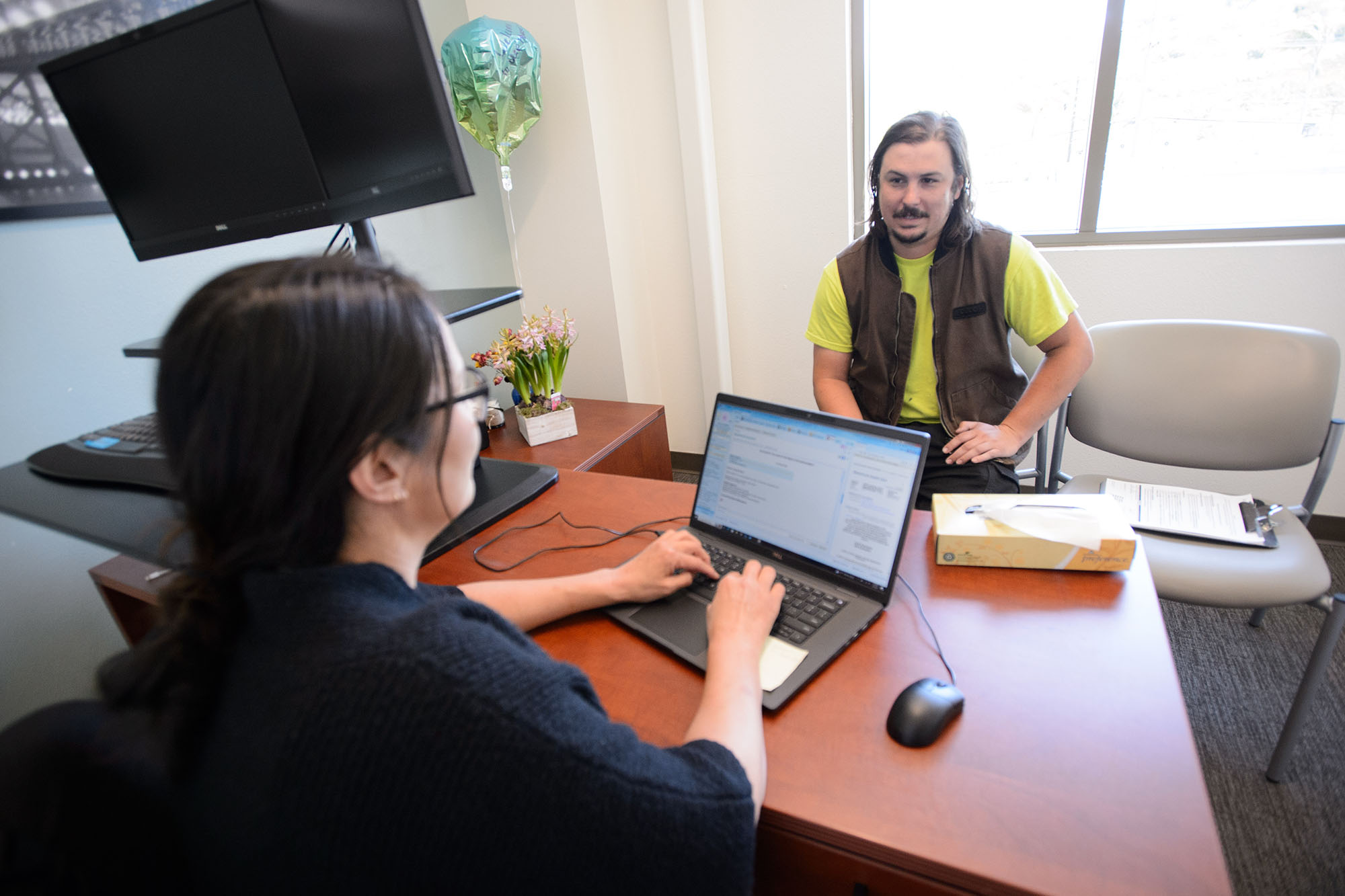 Doctor enters information on computer while talking to patient.