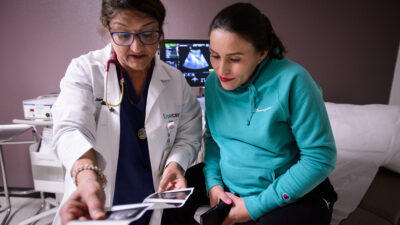 Doctor and patient look at a printout of a sonogram together.