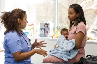 Doctor provides care to a woman and her infant.