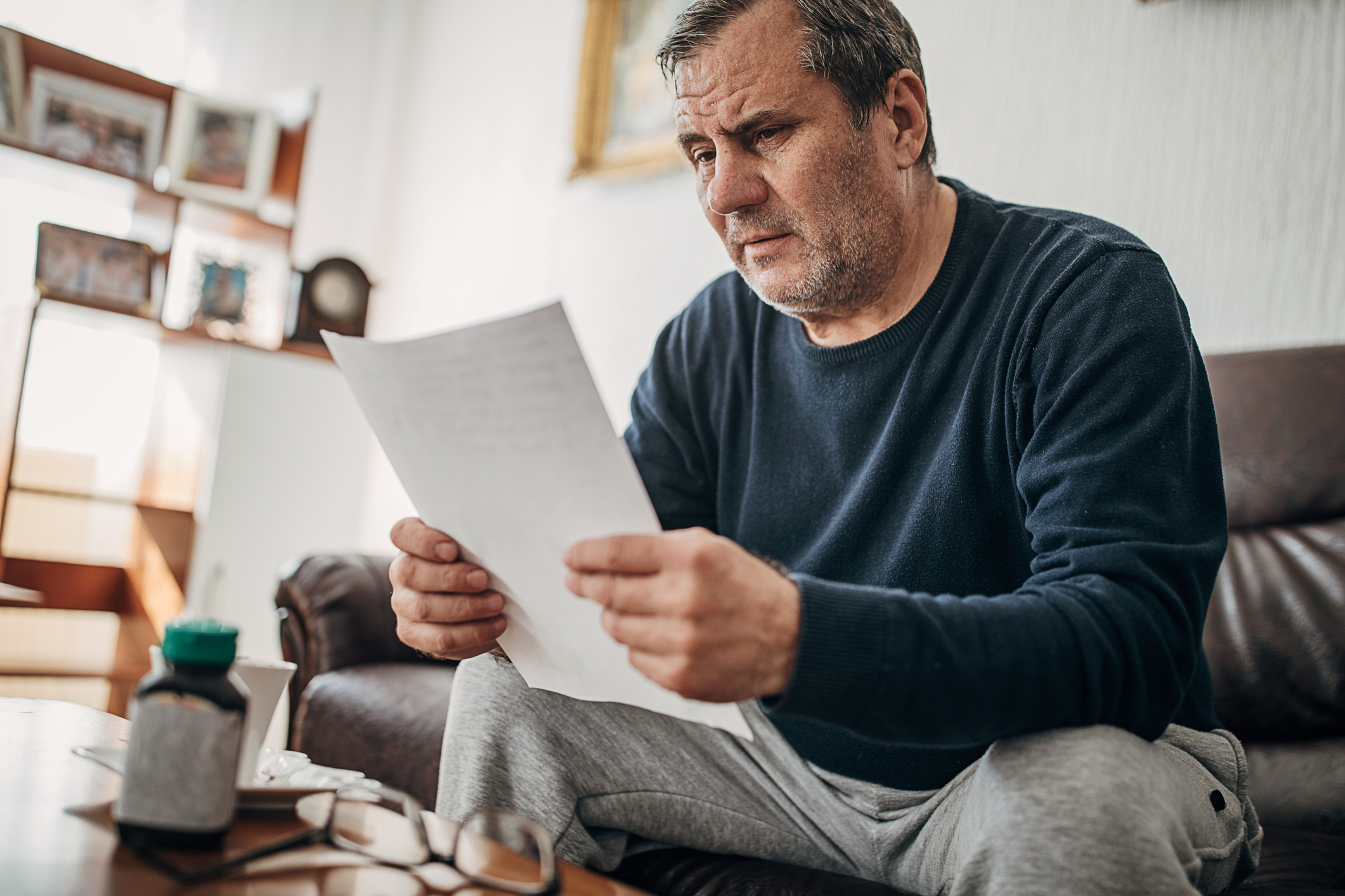 A depressed man reads a letter