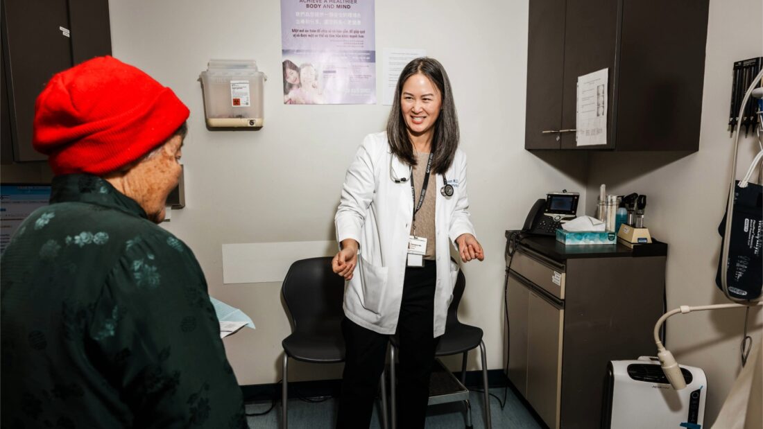 Community health centers older adults - A doctor greets a senior patient in an exam room.