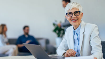 Woman working on a laptop in an office.