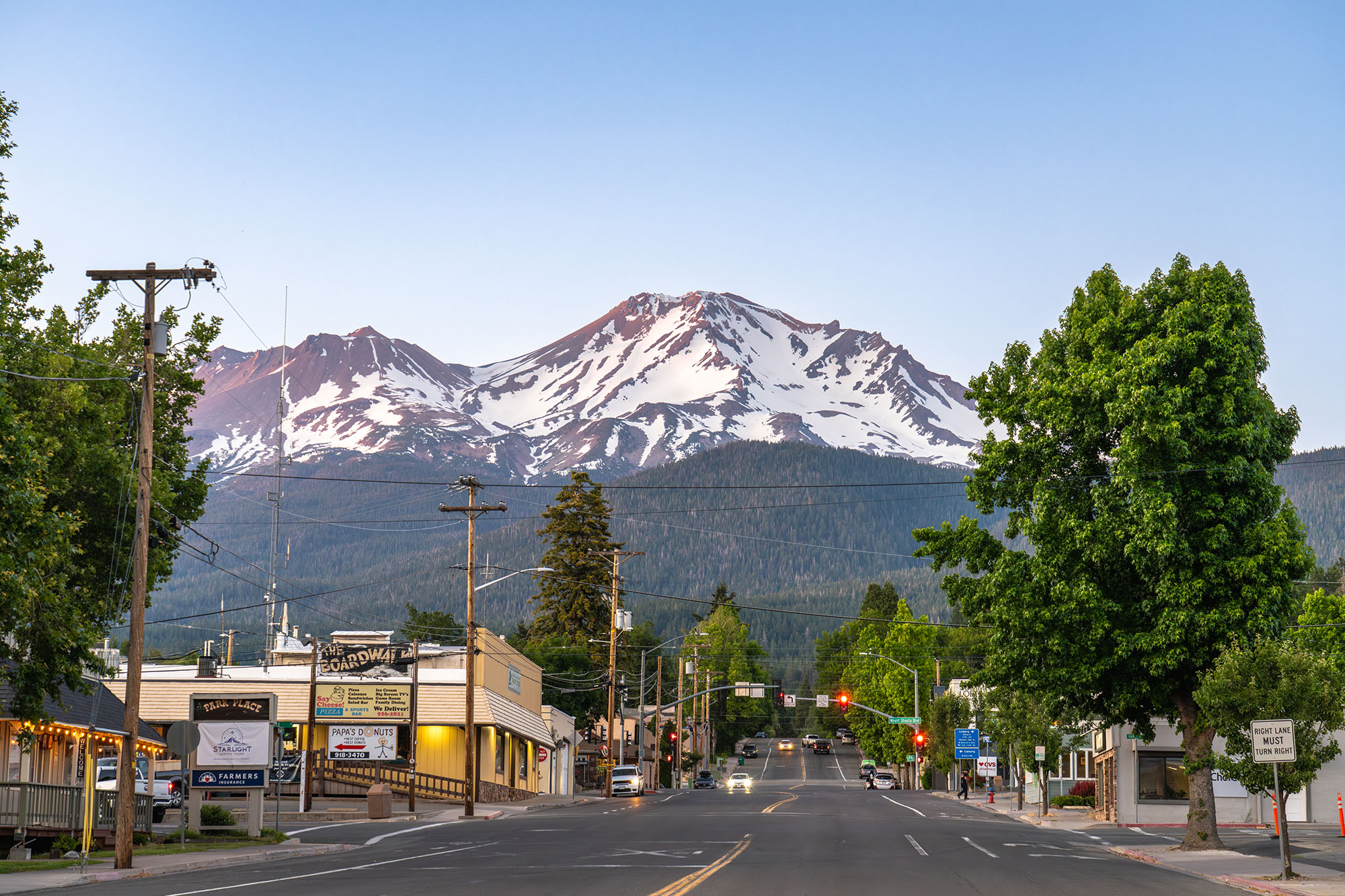 Mount Shasta, California, USA - June 17th 2025: Main street of Mount Shasta town leading towards Mount Shasta Volcano, at dusk in summer