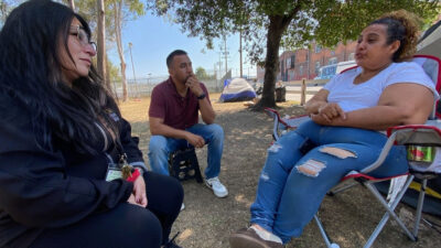 Lisette Carmona, LCSW, Social Work Manager, Clinical Instructor of Family Medicine, Keck School of Medicine of USC alongside Raymond Gonzales, Case Worker at USC Street Medicine speak with patient receiving behavioral health care treatment.