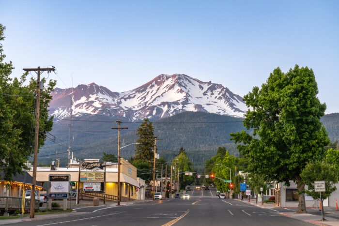 Mount Shasta, California, USA - June 17th 2025: Main street of Mount Shasta town leading towards Mount Shasta Volcano, at dusk in summer