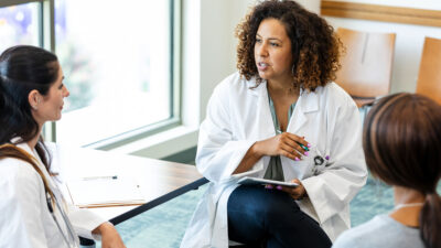 Three members of a medical team sitting at a table talking