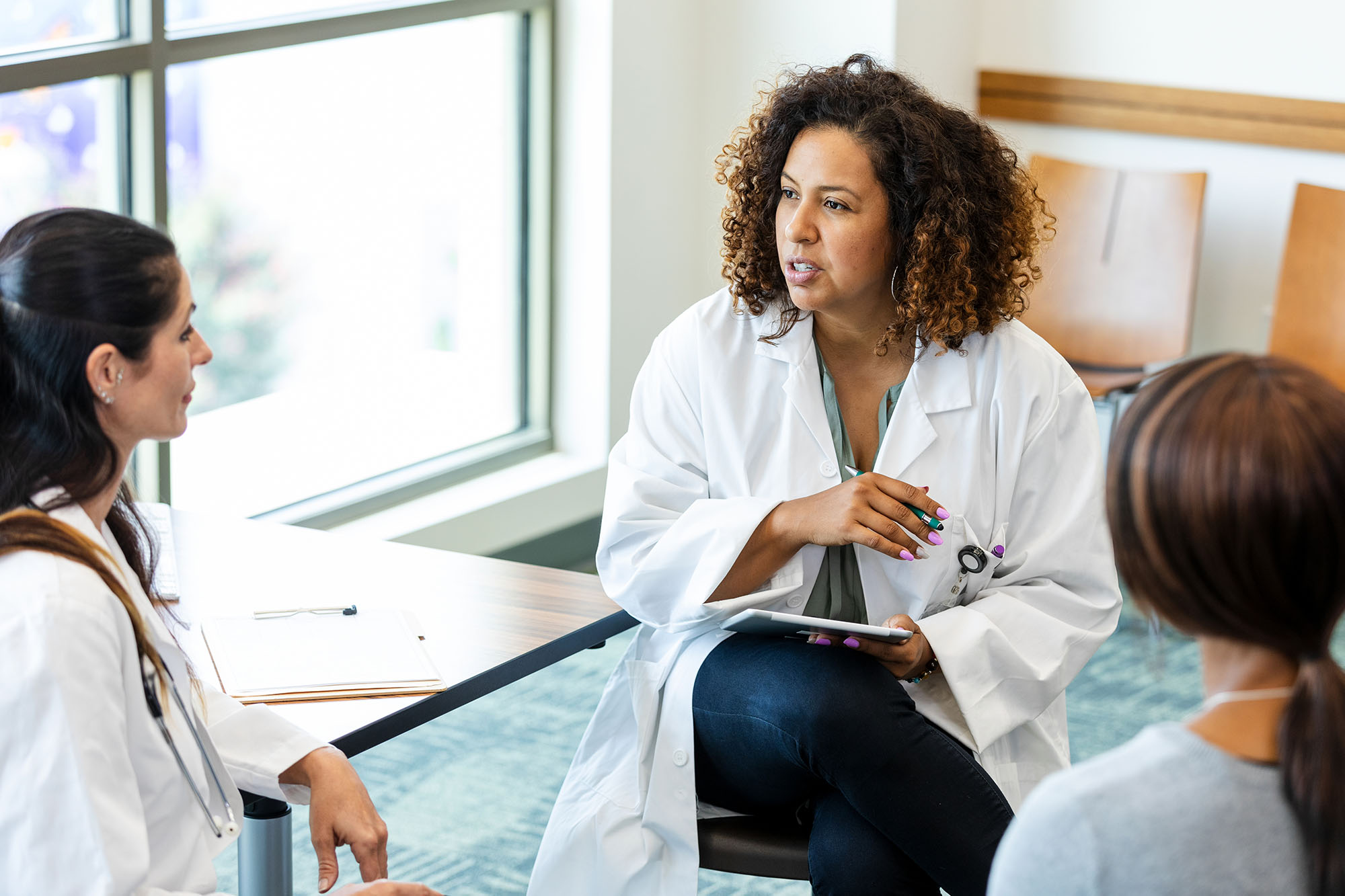 Three members of a medical team sitting at a table talking