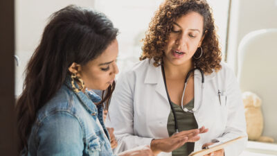 Doctor and patient looking at health care instructions together.