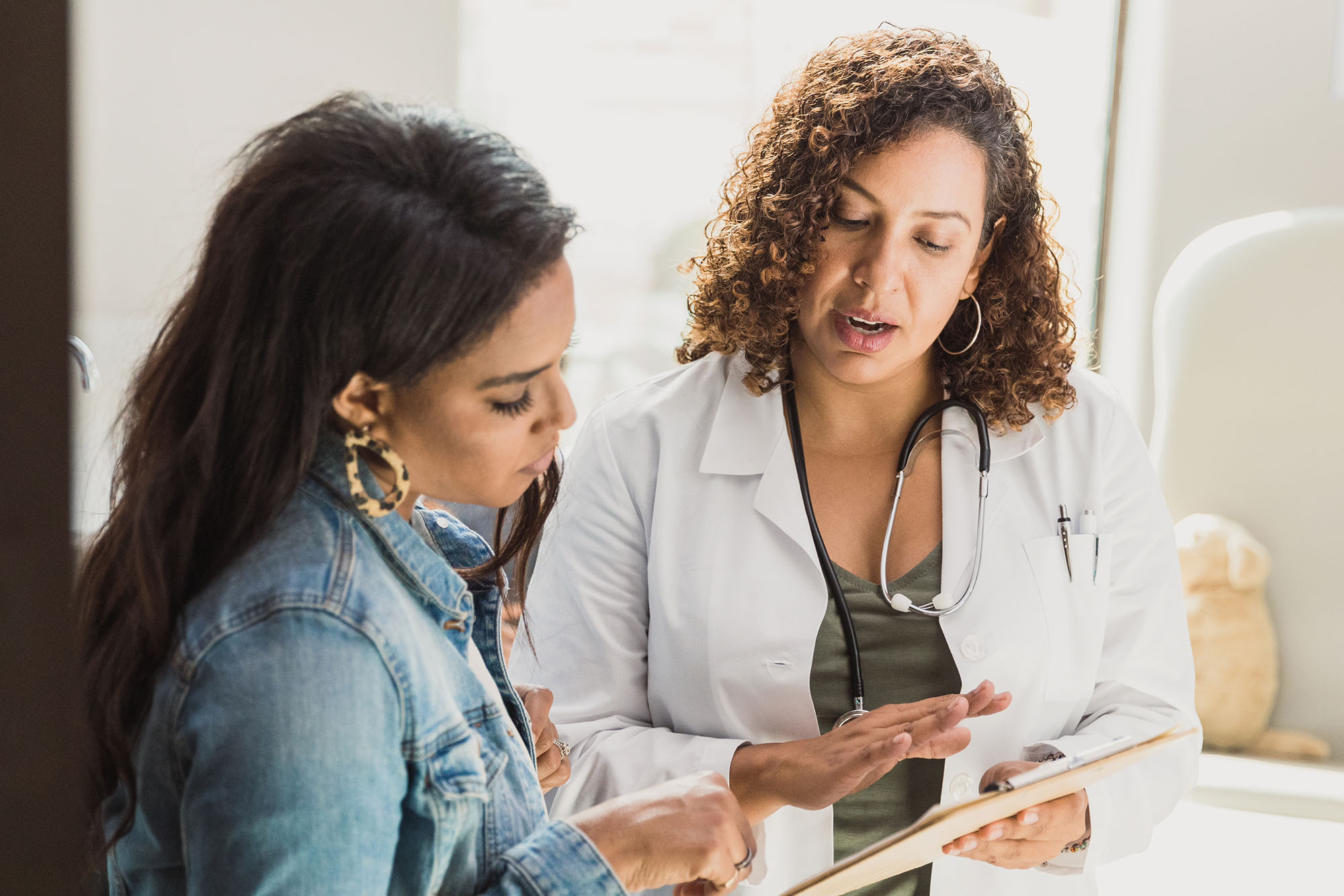 Doctor and patient looking at health care instructions together.