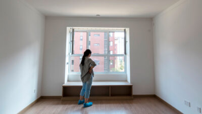 Young woman reading a paper in an empty new apartment